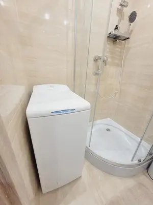 a white toilet in a bathroom with a shower at Castle Street in Kraków