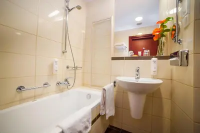 a bathroom with a sink and a bath tub and a sink at Premier Kraków Hotel in Kraków