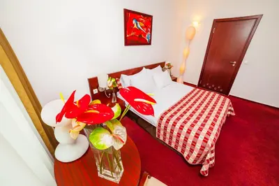 a bedroom with a bed and a vase of flowers on a table at Premier Kraków Hotel in Kraków