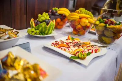 a table with plates of food and bowls of fruit at Premier Kraków Hotel in Kraków