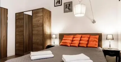 a bedroom with a bed with orange pillows on it at Old Town Apt - Topolowa studio T33 in Kraków