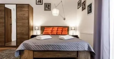 a bedroom with a bed with orange pillows on it at Old Town Apt - Topolowa studio T33 in Kraków