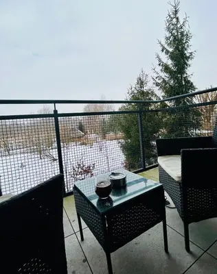 a patio with two chairs and a coffee table on a balcony at Place Oswiecim - underground parking, air conditioning, Self Check In in Oświęcim