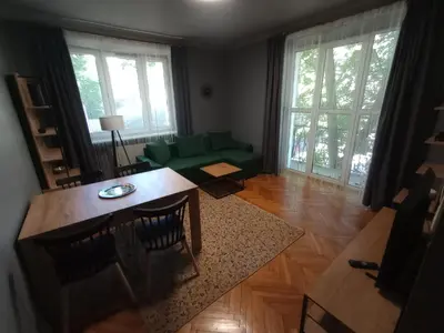 a living room with a table and a green couch at Apartament Humberta in Kraków