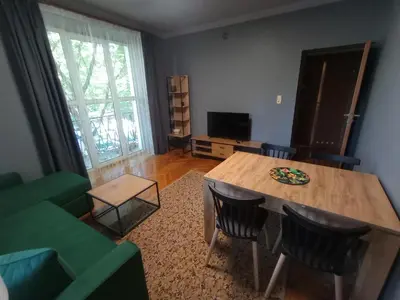 a living room with a table and a green couch at Apartament Humberta in Kraków