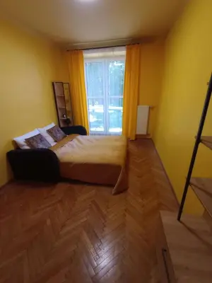 a bedroom with a bed and a large window at Apartament Humberta in Kraków