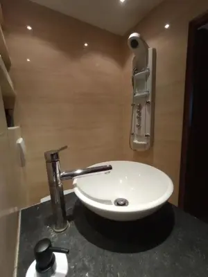 a white sink in a bathroom with a faucet at Apartament Humberta in Kraków