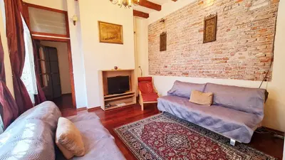 a living room with a couch and a brick wall at Komfortowy Apartament na ul Brackiej 6B in Kraków