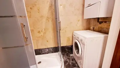 a bathroom with a washing machine and a shower at Komfortowy Apartament na ul Brackiej 6B in Kraków