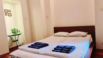 a bedroom with a bed with two blue pillows on it at Komfortowy Apartament na ul Brackiej 6B in Kraków