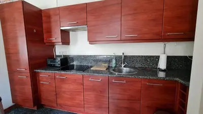 a kitchen with wooden cabinets and a sink at Komfortowy Apartament na ul Brackiej 6B in Kraków