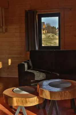 a living room with a couch and two tables at Domki 15 szczytów in Zawoja