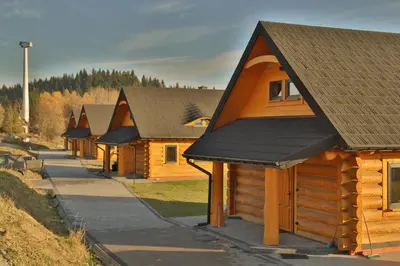 a row of wooden houses in a row at Domki 15 szczytów in Zawoja