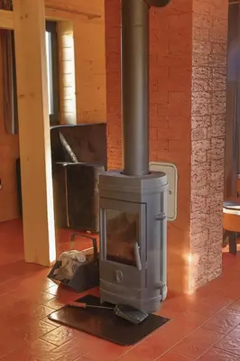 a wood stove in a room with a fireplace at Domki 15 szczytów in Zawoja