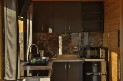 a kitchen with black cabinets and a black refrigerator at Domki 15 szczytów in Zawoja