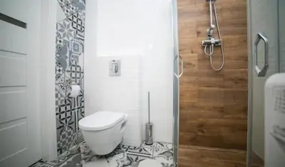 a bathroom with a toilet and a glass shower at Old Town Apt - Wielopole studio W6 in Kraków