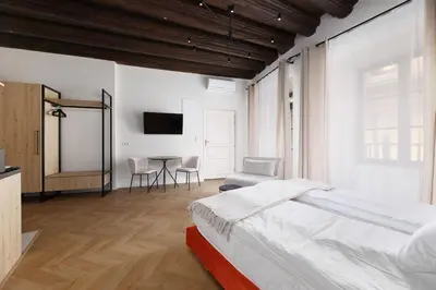 a bedroom with a bed and a table with chairs at Hetman Main Square Apartments in Kraków