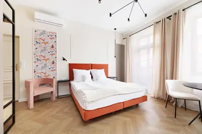 a bedroom with a bed and a table and chairs at Hetman Main Square Apartments in Kraków