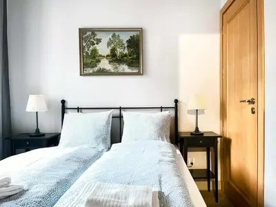 a bedroom with two beds and a picture on the wall at Welcoming Apartments with bedrooms and Air Conditioning, city center in Kraków
