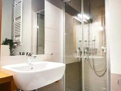 a bathroom with a sink and a shower at Welcoming Apartments with bedrooms and Air Conditioning, city center in Kraków
