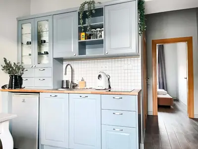 a kitchen with white cabinets and a sink at Welcoming Apartments with bedrooms and Air Conditioning, city center in Kraków