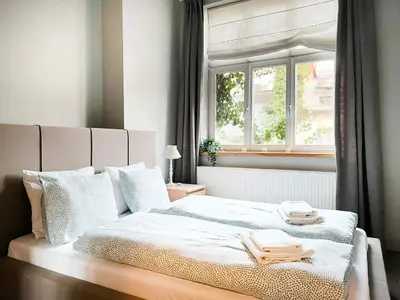 a bedroom with a white bed with a window at Welcoming Apartments with bedrooms and Air Conditioning, city center in Kraków