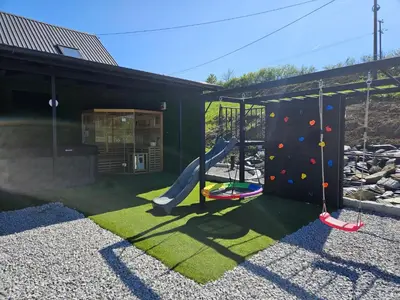 a playground with a slide and a climbing wall at Secret Barn in Michalczowa
