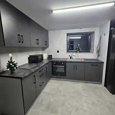 a kitchen with gray cabinets and a sink at Secret Barn in Michalczowa