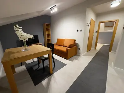 a living room with a table and a chair at Apartamenty N, Trąbki in Wieliczka