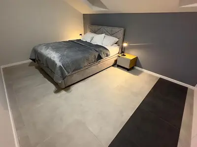 a bedroom with a bed and a tiled floor at Apartamenty N, Trąbki in Wieliczka