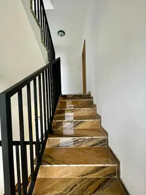 a staircase with wooden floors and a black railing at Apartamenty N, Trąbki in Wieliczka