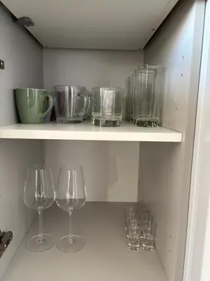 a shelf with wine glasses and bowls on it at Apartament Zielone Wzgórze Pod Turbaczem in Nowy Targ
