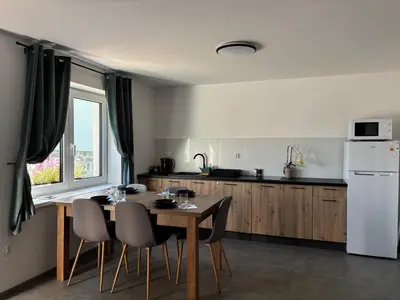 a kitchen with a table and chairs and a white refrigerator at Apartament Zielone Wzgórze Pod Turbaczem in Nowy Targ