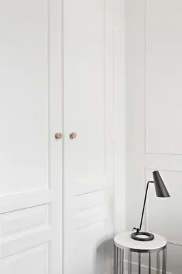 a lamp on a table in front of white cabinets at Starowiślna Apartments by Tyzenhauz in Kraków
