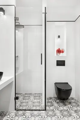 a bathroom with a shower and a black toilet at Starowiślna Apartments by Tyzenhauz in Kraków