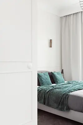 a white bedroom with a bed with blue pillows at Starowiślna Apartments by Tyzenhauz in Kraków