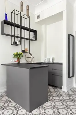 a kitchen with a black counter top and a tile floor at Starowiślna Apartments by Tyzenhauz in Kraków