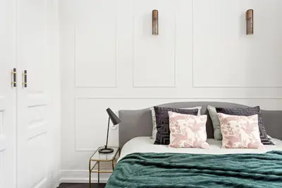 a bedroom with a bed with a green blanket and pillows at Starowiślna Apartments by Tyzenhauz in Kraków