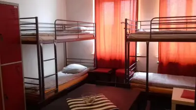 a room with three bunk beds and a table at Art Hostel in Kraków