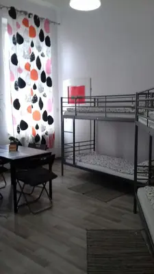 a room with two bunk beds and a table at Art Hostel in Kraków