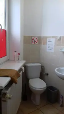 a bathroom with a white toilet and a sink at Art Hostel in Kraków
