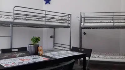 a room with two bunk beds and a table and a desk at Art Hostel in Kraków