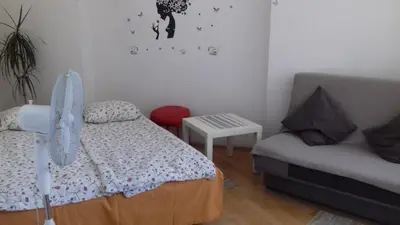 a bedroom with a bed and a couch and a chair at Art Hostel in Kraków