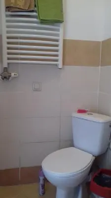a bathroom with a white toilet and a window at Art Hostel in Kraków