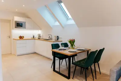 a kitchen and dining room with a table and chairs at Apart Home Raba Wyżna in Raba Wyżna