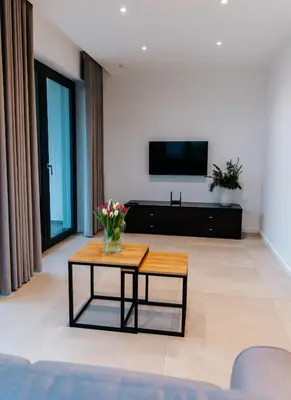 a living room with a table and a tv at Apart Home Raba Wyżna in Raba Wyżna