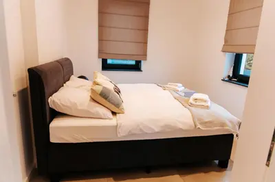 a bed with white sheets and pillows in a bedroom at Apart Home Raba Wyżna in Raba Wyżna