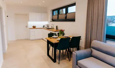 a kitchen and living room with a table and chairs at Apart Home Raba Wyżna in Raba Wyżna