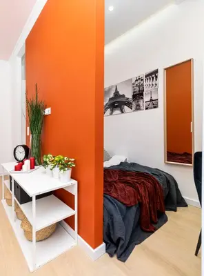 a bedroom with an orange wall and a bed at Apartment near Main Station - Bosacka 8 street in Kraków