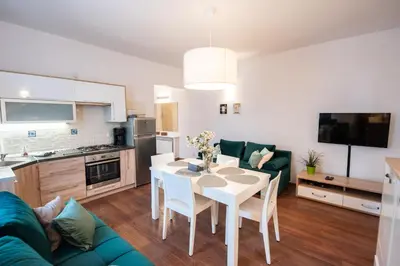 a kitchen and living room with a table and a couch at Cozy apartment - Bosacka 10 street in Kraków